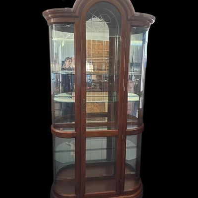 Sale Photo Thumbnail #470: 86"T × 44"W × 15"D Tall wood-framed curio cabinet with curved glass sides and arched top. Lighted interior with 5 glass shelves. Measurements: approx. 86" tall × 44" wide × 15" deep. Great for displaying collectibles. Local   in   / Shreveport area.  