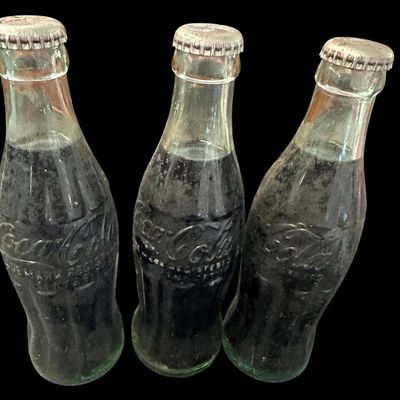 Sale Photo Thumbnail #850:  Three capped / still-full 6.5 oz Coca-Cola bottles. Two Monroe  one Shreveport. Do not wash. Collectible  not for drinking.