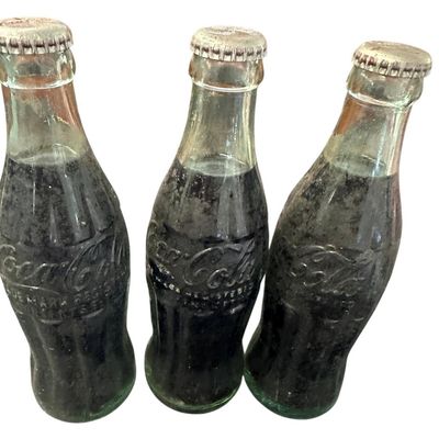 Sale Photo Thumbnail #851:  Three capped / still-full 6.5 oz Coca-Cola bottles. Two Monroe  one Shreveport. Do not wash. Collectible  not for drinking.