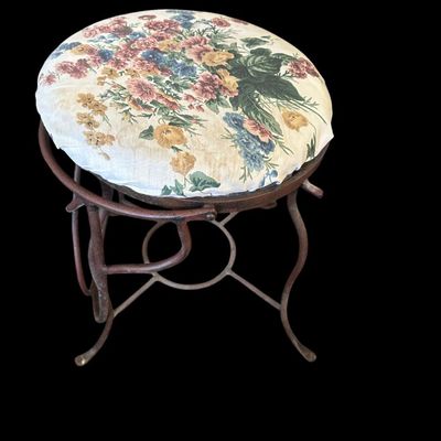 Sale Photo Thumbnail #934: Round vanity stool featuring a dark metal base with looping wire scrollwork  stretcher ring support  and padded floral chintz fabric seat cushion.  