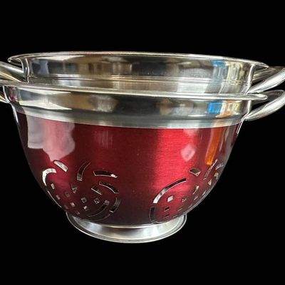 Sale Photo Thumbnail #988:  Two Stainless Steel Colanders with Red Exterior and Apple Cutout Design.                           
