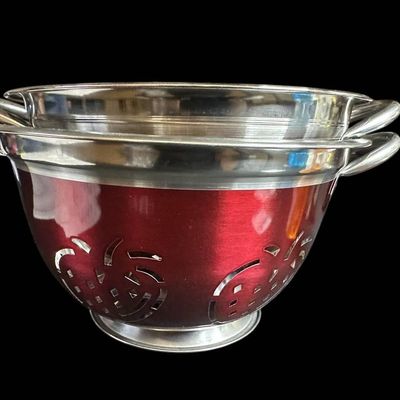 Sale Photo Thumbnail #989:  Two Stainless Steel Colanders with Red Exterior and Apple Cutout Design.                           