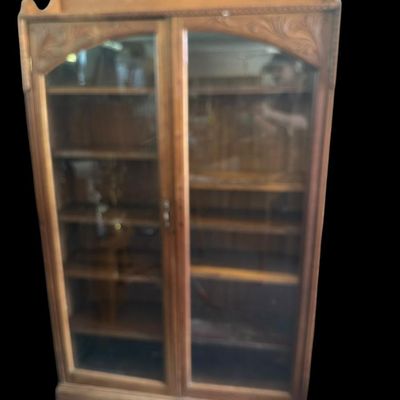 Sale Photo Thumbnail #1062: 70 X 41 X 11 Antique Oak Carved 2-Door Glass Bookcase / Display Cabinet  features solid oak construction  carved floral spandrels above double full-length glass doors  upper gallery backsplash  and multi-tier adjustable interior shelving. (70" H x 41" W x