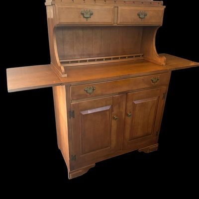 Sale Photo Thumbnail #1068: 53"T × 18"D × 38"W (down) / 62"W (up) Upper hutch with spindle gallery top rail and dual small drawers; main cabinet features drop-leaf sides  single wide drawer over double cabinet doors  and antique brass batwing bail handles. Dimensions: 53" H x 18" 