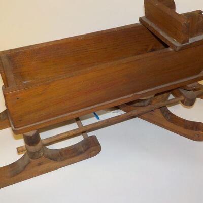 Hand crafted wooden doll sled and primate picture.