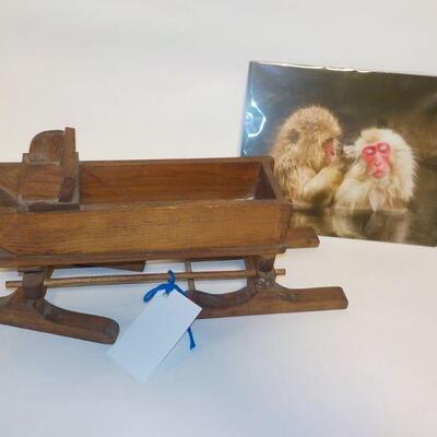 Hand crafted wooden doll sled and primate picture.
