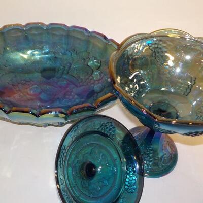 Vintage Blue Carnival Glass  blue iridescent carnival glass: footed candy dish with lid, two goblets, oval footed bowl with fruit on...