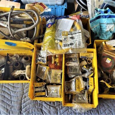 lot 132 =-Yellow bins of assorted plumbing parts on top of table