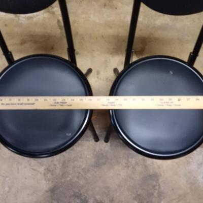 2 black small folding chairs