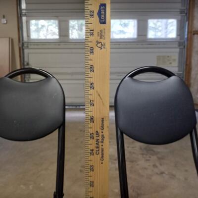 2 black small folding chairs