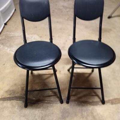 2 black small folding chairs