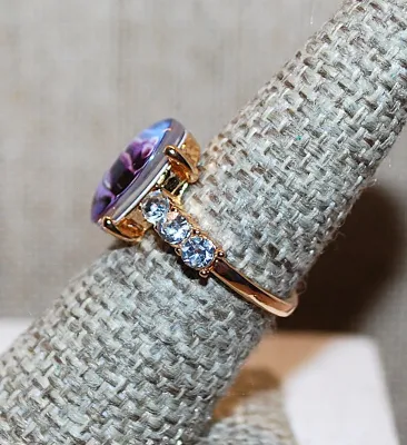 **NEW ARRIVAL** Size 6¾ Oval "PURPLE ROSE WINDOW" RING with Triple Clear Stones Side Accents on a Gold Tone Setting and Band...