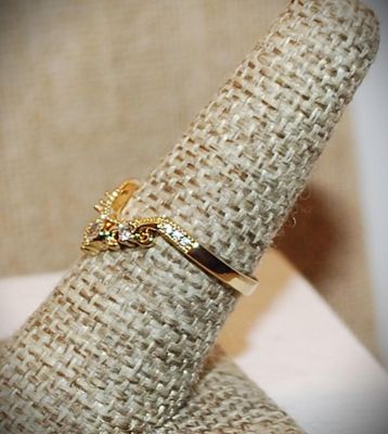 Size 7 Rounded "V" Style Curve Ring with 3 Main Clear Stones on a Gold Tone Band (2.1g)