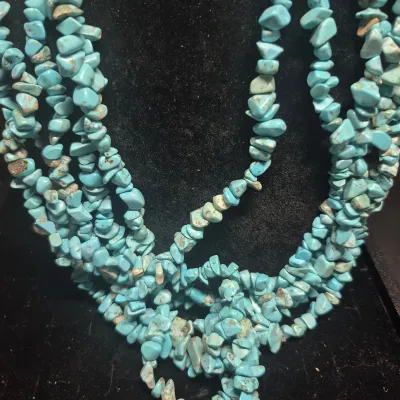 Sale Photo Thumbnail #7: This Navajo 6 strand Turquoise Necklace features a stunning array of 7mm tumbled turquoise beads in a beautiful 13 inch strand. The necklace is accented with a steel bell gather, adding a unique touch to the traditional Navajo design. Crafted with silver 
