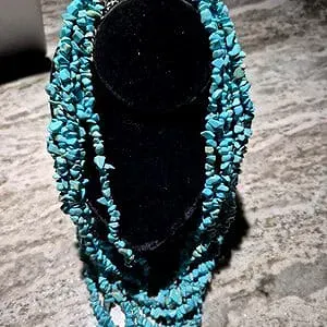 Sale Photo Thumbnail #6: This Navajo 6 strand Turquoise Necklace features a stunning array of 7mm tumbled turquoise beads in a beautiful 13 inch strand. The necklace is accented with a steel bell gather, adding a unique touch to the traditional Navajo design. Crafted with silver 