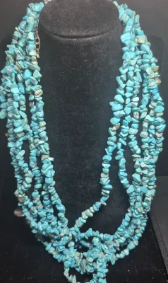 Sale Photo Thumbnail #5: This Navajo 6 strand Turquoise Necklace features a stunning array of 7mm tumbled turquoise beads in a beautiful 13 inch strand. The necklace is accented with a steel bell gather, adding a unique touch to the traditional Navajo design. Crafted with silver 