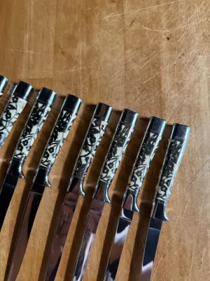 Sale Photo Thumbnail #172: .Beautiful set of 10 vintage mid-century modern steak knives made by Carvel Hall (Briddell). These feature a gorgeous, detailed metal floral overlay pattern on the handles.

Excellent vintage condition with minimal wear. 2 knives show small wear on the ha