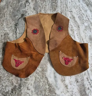 Sale Photo Thumbnail #293: Keyston Bros. "Lasso 'Em Bill" kids suede leather vest
> steer & flower applique still original
> suede in great shape....ready for the next cow kid !
> minor stitch repair under arm
> Size: 10" shoulders / 15" body / 14" height