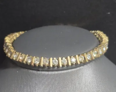 Sale Photo Thumbnail #190: Vintage gold tone Tennis Bracelet ~ Cz stones & MCM design
> each stone is housed in a square bumper bracelet [bar set]
> round stones give a continuous line of clear faceted CZ stones
> excellent condition / snap clasp  / 7.5" long
