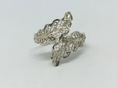 Sale Photo Thumbnail #197: Featuring a diamond cut filigree design, this 925 silver ring shows the popular image of the laurel wreath, which consists of interlocked leaves. Often associated with athletic and academic excellence, the laurel wreath symbolizes victory and greatness. A