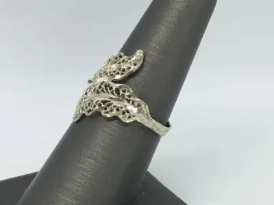 Sale Photo Thumbnail #199: Featuring a diamond cut filigree design, this 925 silver ring shows the popular image of the laurel wreath, which consists of interlocked leaves. Often associated with athletic and academic excellence, the laurel wreath symbolizes victory and greatness. A