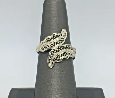 Sale Photo Thumbnail #198: Featuring a diamond cut filigree design, this 925 silver ring shows the popular image of the laurel wreath, which consists of interlocked leaves. Often associated with athletic and academic excellence, the laurel wreath symbolizes victory and greatness. A