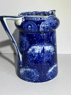 Sale Photo Thumbnail #108: ROWLAND MARSELLUS HISTORICAL POTTERY PITCHER IN BLUE & WHITE WITH VIGNETTES OF VARIOUS HISTORICAL SCENES INCL WILLIAM PENNS TREATY, THE LANDING OF COLUMBUS, ETC. 7-1/2" TALL. $15 DOMESTIC SHIPPING.