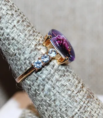 **NEW ARRIVAL** Size 7¾ Oval "PURPLE ROSE WINDOW" RING with Triple Clear Stones Side Accents on a Gold Tone Setting and Band...