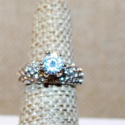 Size 6 Highrise Round Main Stone Ring with "Waves" of Accents Stones on a Silver Tone Band (4.1g)