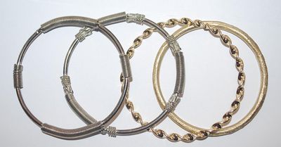 Collection of 4 BRACELETS (-2½"+ Opening) with Silver "Springs" and Brushed and Swirls Gold Tone Settings
