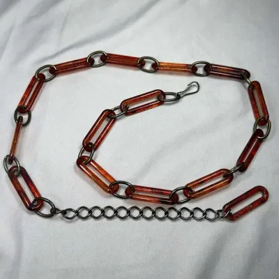 Sale Photo Thumbnail #236: Original 1960-70s Chain Link Waist Belt, Faux Tortoise Shell Lucite and Brass
Made of acrylic/lucite and brass

Full length (end to end) is 42 inches

Clasp works fine, no broken pieces or anything. 

Original, from the 1960-70s
