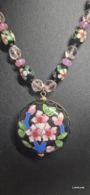 Sale Photo Thumbnail #439: The Cloisonne style pendant is large with a black background and pink flowers. The flowers appear on both sides of the pendant. The necklace is long with a chain that is interspersed with beads. The pendant is in perfect condition.
Cloisonne enameled earr