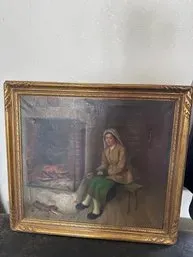 Antique oil painting depicting a woman seated by a fireplace, housed in an ornate gilt wood frame.