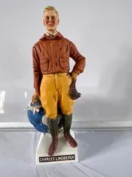 Vintage ceramic Charles Lindbergh decanter, depicting the aviator in flight gear standing beside a globe.