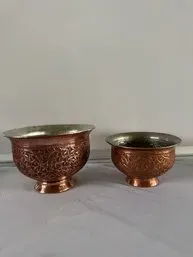 Pair of vintage Middle Eastern or Persian hand-chased copper bowls with silver-toned interiors and intricate floral engraving.