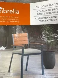 Sunbrella outdoor seat pad packaging showing a modern patio chair with a light gray cushion.