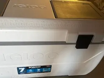 Large white Igloo marine cooler featuring a molded-in fish ruler on the lid and a black latch closure.