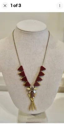 Sale Photo Thumbnail #92: A J. Crew statement necklace featuring a brass-tone chain and hardware. The design showcases geometric triangular elements in a deep burgundy/maroon hue, accented with clear rhinestones, a central marquise-cut stone, and dangling brass-tone spikes. Includ
