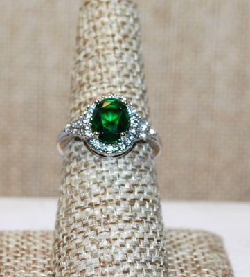 Size 7 Single Green Oval Cut Center Stone Ring with Full Surround on a Silver Tone Band (3.7g)