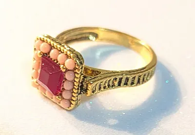 **NEW ARRIVAL** SIZE 11 Gold Tone Ring Featuring a RED OPAQUE CENTER Stone. Surrounded by Small Round Pink Beads + Rope Edging. Shoulders...