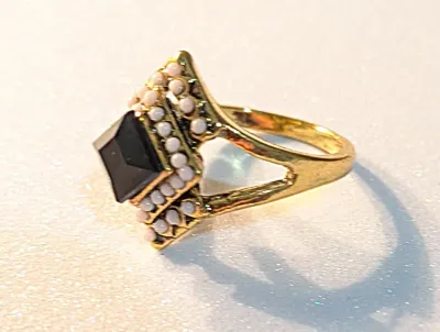 **NEW ARRIVAL** SIZE 7½ RING Features a Gold Tone Band and Setting with Black Center Stone surrounded with WHITE Globes. It Features a...