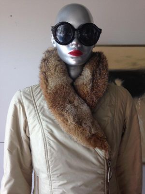 Vintage beige quilted winter jacket featuring a thick, natural brown fur collar, displayed on a silver mannequin with oversized sunglasses.