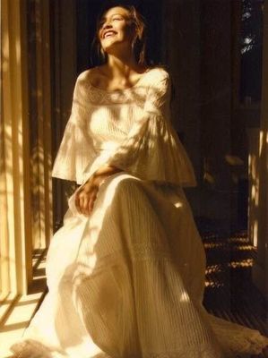 Vintage 1970s white cotton gauze prairie dress featuring bell sleeves, lace trim, and a tiered maxi skirt.
