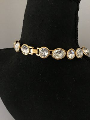 Sale Photo Thumbnail #3: A vintage gold-tone collar necklace by Napier featuring bezel-set round and oval faceted clear crystals/rhinestones. Secured with a fold-over clasp stamped NAPIER. In good condition with bright stones and minor surface wear typical of age. See photos with