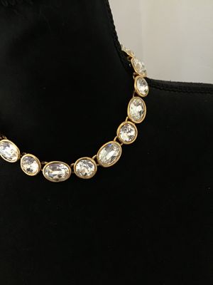 Sale Photo Thumbnail #4: A vintage gold-tone collar necklace by Napier featuring bezel-set round and oval faceted clear crystals/rhinestones. Secured with a fold-over clasp stamped NAPIER. In good condition with bright stones and minor surface wear typical of age. See photos with