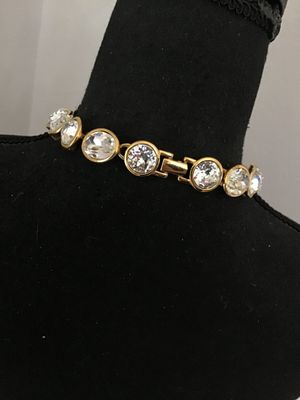 Sale Photo Thumbnail #2: A vintage gold-tone collar necklace by Napier featuring bezel-set round and oval faceted clear crystals/rhinestones. Secured with a fold-over clasp stamped NAPIER. In good condition with bright stones and minor surface wear typical of age. See photos with