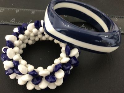 Sale Photo Thumbnail #10: Set of two vintage navy blue and white costume jewelry bracelets. Includes one chunky resin/plastic striped bangle bracelet and one cluster beaded stretch bracelet featuring faceted navy blue and smooth white teardrop-shaped beads. Both items are in good 