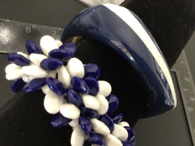 Sale Photo Thumbnail #8: Set of two vintage navy blue and white costume jewelry bracelets. Includes one chunky resin/plastic striped bangle bracelet and one cluster beaded stretch bracelet featuring faceted navy blue and smooth white teardrop-shaped beads. Both items are in good 
