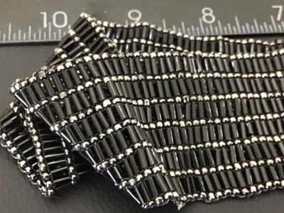 Sale Photo Thumbnail #18: Vintage wide beaded belt featuring black bugle beads and silver-tone seed beads arranged in a textured grid pattern. Features an oval silver-tone slide or hook buckle. Good vintage condition with light wear consistent with age.