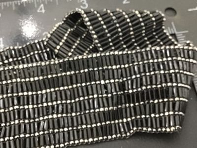 Sale Photo Thumbnail #16: Vintage wide beaded belt featuring black bugle beads and silver-tone seed beads arranged in a textured grid pattern. Features an oval silver-tone slide or hook buckle. Good vintage condition with light wear consistent with age.